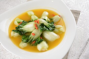 stir fried small cabbage with Chinese herbal in yellow chicken stock soup in white background asian halal vegan menu