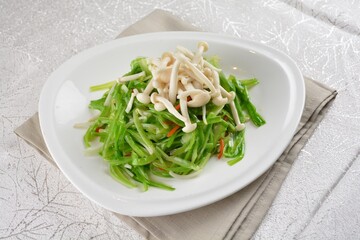 stir fried dragon vegetable with white mushroom vegetarian in soy sauce in white background asian halal vegan menu