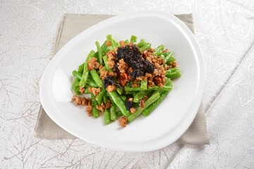 stir fried green long bean vegetables with mini shrimp paste and garlic in white background asian halal vegan menu