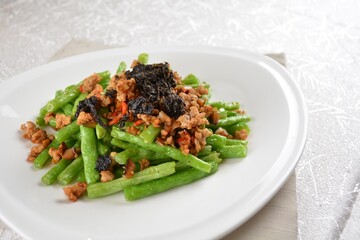 stir fried green long bean vegetables with mini shrimp paste and garlic in white background asian halal vegan menu