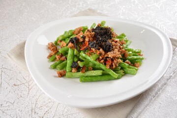 stir fried green long bean vegetables with mini shrimp paste and garlic in white background asian halal vegan menu