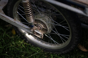 Obraz premium An old motorcycle wheel parked in the park
