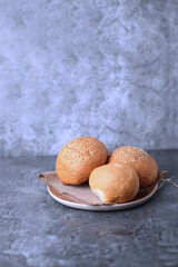 three buns of different kinds on wooden plate isolated on gray background. Vertical image