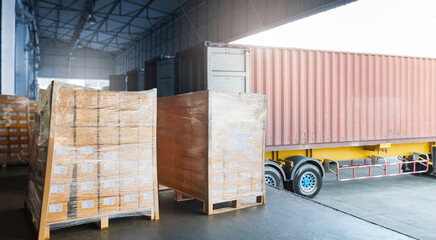Stacked of Package Boxes on Pallets Load with Cargo Container. Trailer Truck Parked Loading at Dock Warehouse. Delivery. Shipping Warehouse Logistics. Cargo Freight Truck Transportation.	