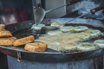 The meat in batter is fried in oil on the street. Street food market in Asia. Phnom Penh, Cambodia