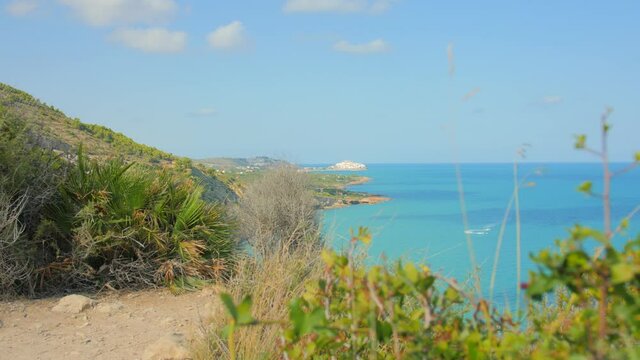 Distant View Of Seafront Medieval Peniscola Castle From Serra d'Irta Natural Park On Mediterranean Coast In Peniscola, Spain. handheld shot