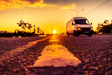 Sunset in the country, the van on the highway. Wide angle view of the level of the dividing line