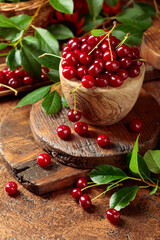 Ripe red cherries in a wooden dish.