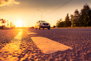 Sunset in the country, the car on the highway. Wide angle view of the level of the dividing line