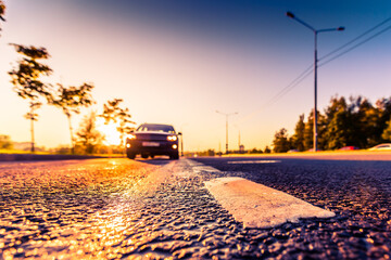 Obraz premium Sunset after rain, the car on the highway. Wide angle view of the level of the dividing line