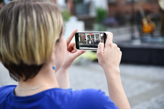 The girl holds a mobile phone in her hands and shoots a video