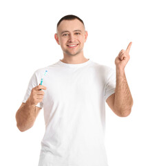 Man with tooth brush pointing at something on white background