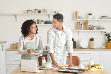 African-American brother and sister making cookies in kitchen