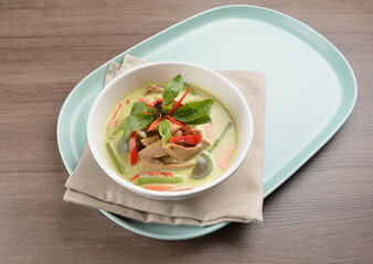 thai spicy chili green curry hot soup with vegetarian meat in bowl blue plate on wood background asian halal vegan menu