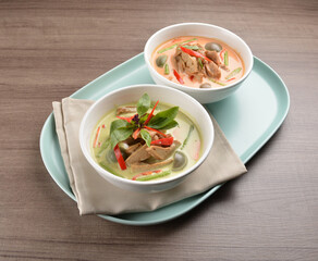 thai spicy chili red and green curry hot soup with vegetarian meat in bowl blue plate on wood background asian halal vegan menu