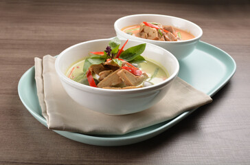thai spicy chili red and green curry hot soup with vegetarian meat in bowl blue plate on wood background asian halal vegan menu