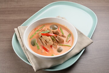 thai spicy chili red curry hot soup with vegetarian meat in bowl blue plate on wood background asian halal vegan menu