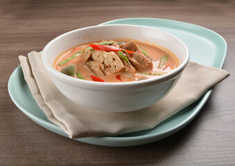 thai spicy chili red curry hot soup with vegetarian meat in bowl blue plate on wood background asian halal vegan menu