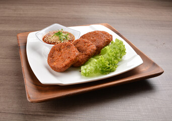 deep fried hash brown round potato cake with Thai spicy chilli sauce on wood background asian halal vegan menu