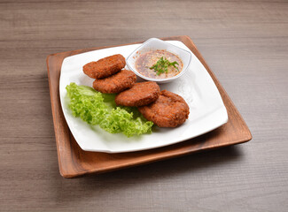 deep fried hash brown round potato cake with Thai spicy chilli sauce on wood background asian halal vegan menu