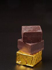 Broken pieces of chocolate and cocoa powder on a black background