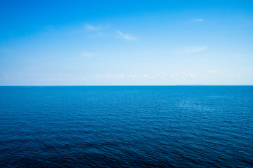 Tranquil minimalist landscape with a smooth blue sea surface with calm waters with a horizon and...