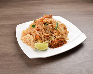 wok stir fried kway teow rice noodle mee goreng with vegetable in spicy soy chilli sauce on wood background asian halal vegan menu