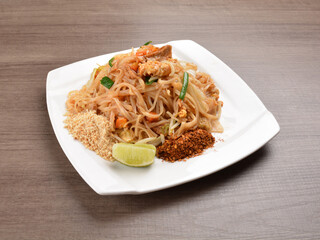 wok stir fried kway teow rice noodle mee goreng with vegetable in spicy soy chilli sauce on wood background asian halal vegan menu