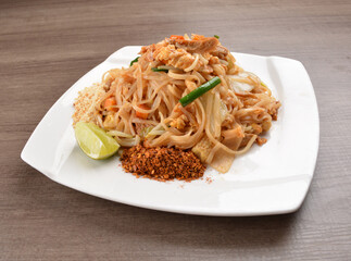 wok stir fried kway teow rice noodle mee goreng with vegetable in spicy soy chilli sauce on wood background asian halal vegan menu
