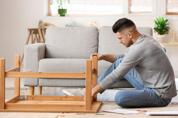 Young man assembling furniture at home