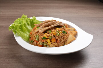 vegetarian nasi goreng fried rice with pineapple, vegetables meat in spicy chilli sambal sauce on wood background asian halal vegan menu
