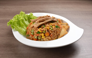 vegetarian nasi goreng fried rice with pineapple, vegetables meat in spicy chilli sambal sauce on wood background asian halal vegan menu