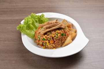 vegetarian nasi goreng fried rice with pineapple, vegetables meat in spicy chilli sambal sauce on wood background asian halal vegan menu