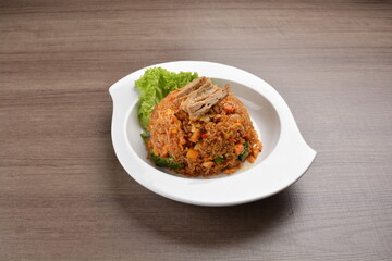 vegetarian nasi goreng fried rice with pineapple, vegetables meat in spicy chilli sambal sauce on wood background asian halal vegan menu