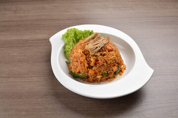 vegetarian nasi goreng fried rice with pineapple, vegetables meat in spicy chilli sambal sauce on wood background asian halal vegan menu