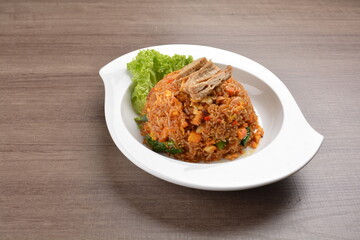 vegetarian nasi goreng fried rice with pineapple, vegetables meat in spicy chilli sambal sauce on wood background asian halal vegan menu
