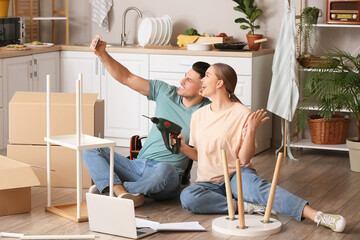 Young couple taking selfie while assembling furniture at home