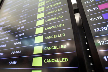 flight cancellations in Bangkok airport on departure board screen, cancelled trip due to coronavirus COVID-19 - obrazy, fototapety, plakaty