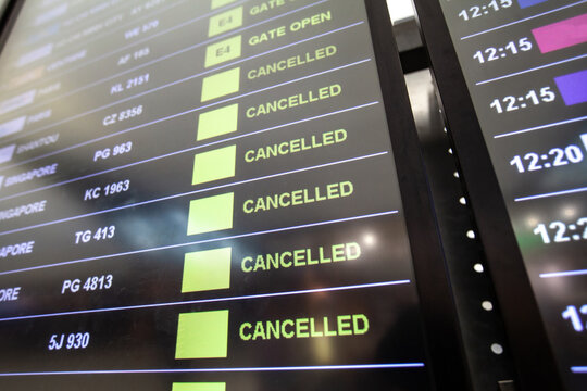 flight cancellations in Bangkok airport on departure board screen, cancelled trip due to coronavirus COVID-19