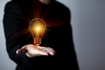 Businessman holding a virtual light bulb in his hand. concept of new ideas, innovation