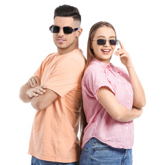 Young couple wearing stylish sunglasses on white background