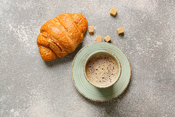 Cup of coffee with croissant and sugar on grunge background