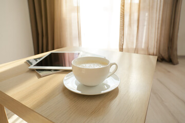 Cup of coffee on table in room