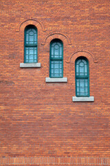 Fototapeta na wymiar red brick wall round arch windows with stone traditional gothic background