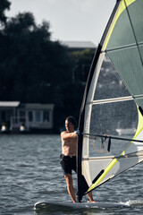 Windsurfer surfing on a windy day at the city river.