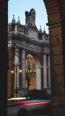 Fototapeta premium Lunga esposizione di monumento storico a forma di arco, situato in rimini, con scie luminose di macchine