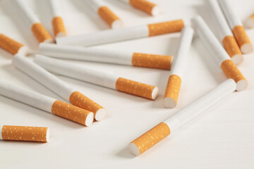image of several commercially made pile cigarette on white  background. or Non smoking campaign concept, tobacco pattern top view.
