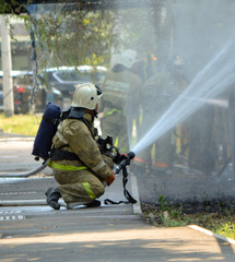 a firefighter extinguishes a fire by hosing water