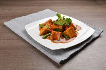 deep fried bean curd tofu with spicy sambal chilli sauce on wood background asian halal vegan menu