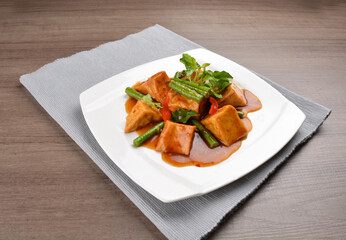 deep fried bean curd tofu with spicy sambal chilli sauce on wood background asian halal vegan menu
